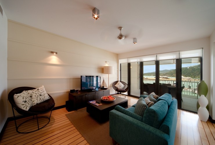 Foto di un piccolo soggiorno minimal aperto con pareti beige, pavimento in bambù e TV autoportante