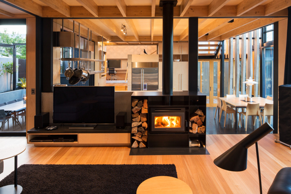 Imagen de salón con rincón musical abierto contemporáneo con suelo de madera en tonos medios, televisor independiente y estufa de leña