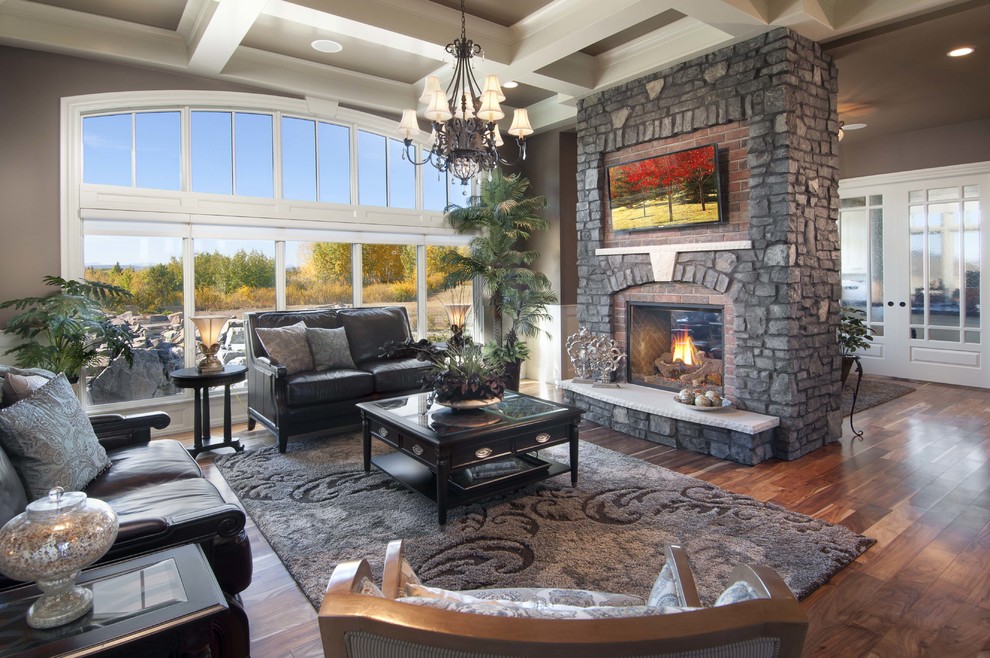 Inspiration for a medium sized classic open plan living room in Calgary with brown walls, medium hardwood flooring, a two-sided fireplace, a brick fireplace surround and a wall mounted tv.