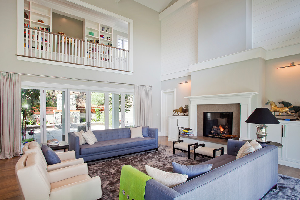 Classic living room in Los Angeles with white walls, a standard fireplace and feature lighting.