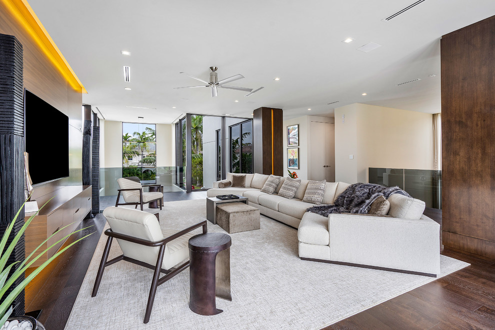 Foto di un grande soggiorno moderno aperto con pareti marroni, pavimento in legno massello medio, TV a parete e pavimento marrone