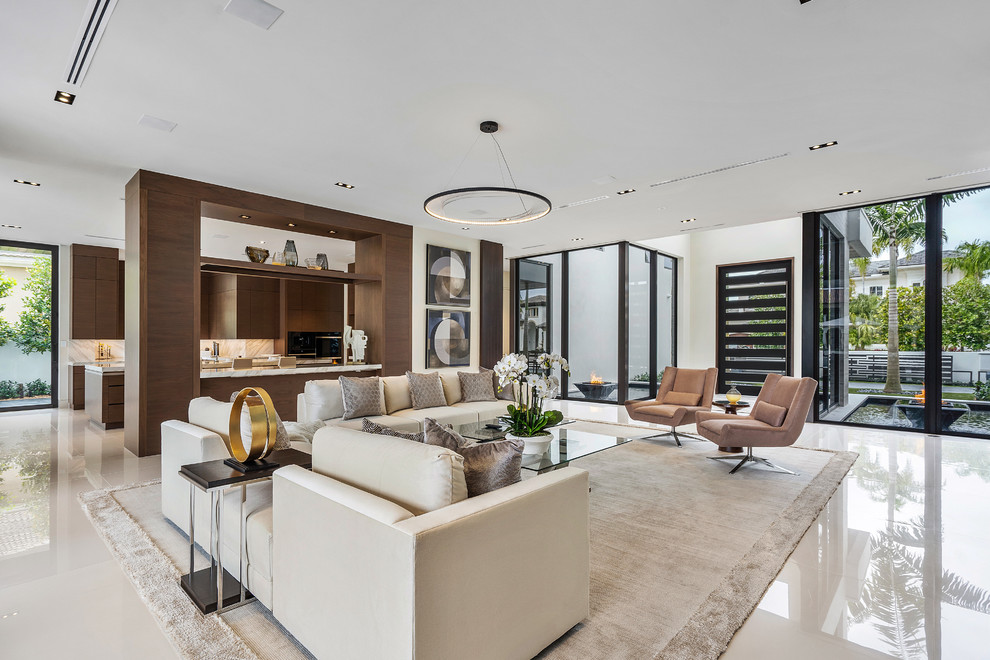 Photo of a large modern open plan living room in Miami with brown walls, marble flooring, a wall mounted tv and white floors.