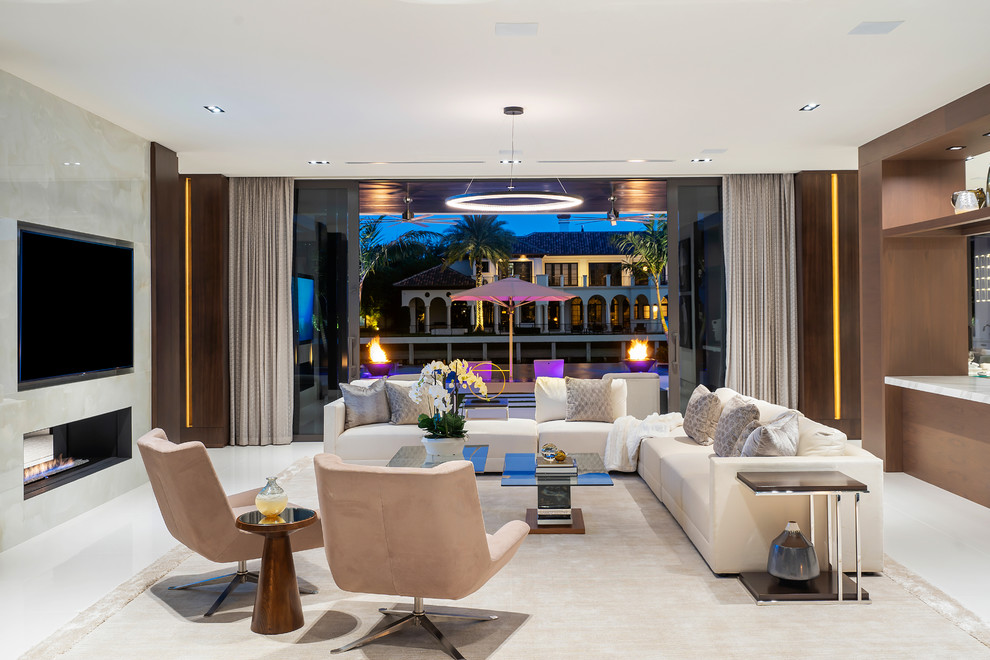 This is an example of a large modern open plan living room in Miami with brown walls, marble flooring, a ribbon fireplace, a stone fireplace surround, a wall mounted tv and white floors.