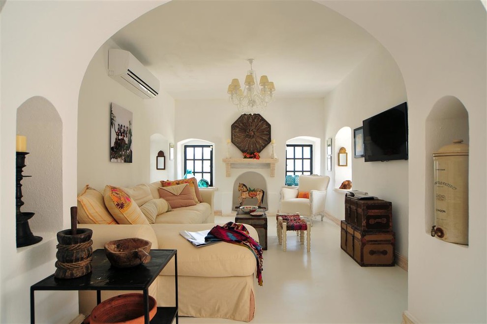 Foto de salón cerrado mediterráneo con paredes blancas, televisor colgado en la pared y arcos