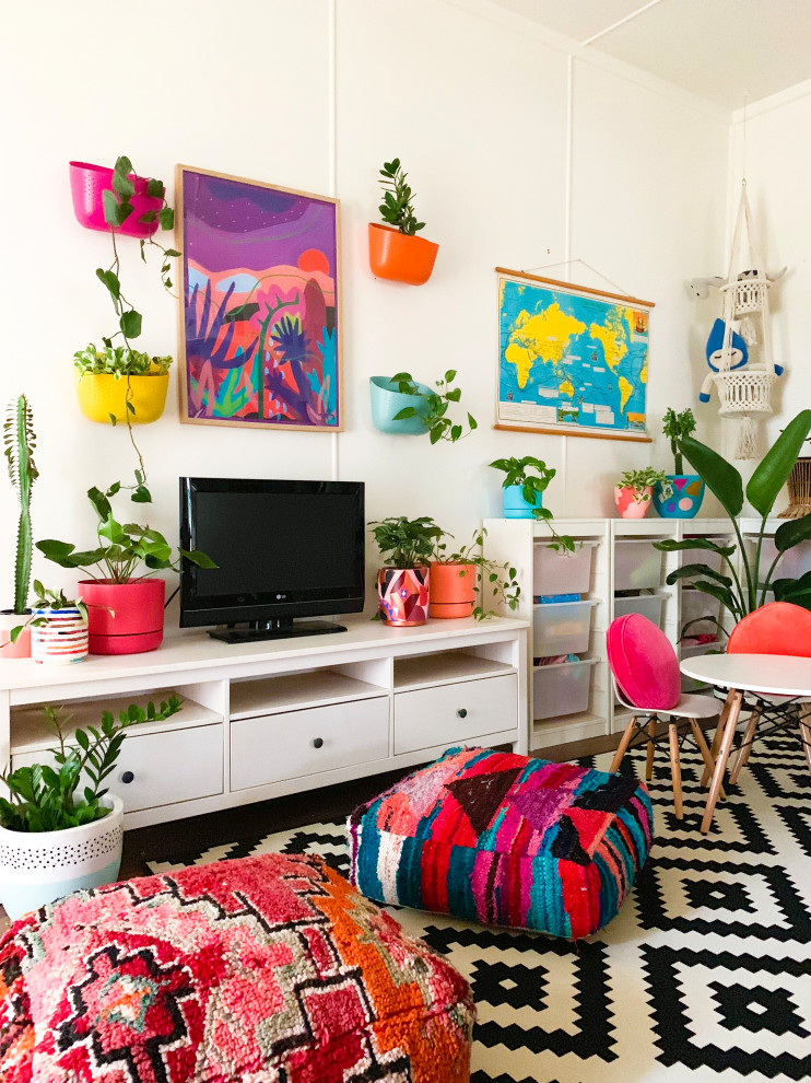 На фото: гостиная комната в стиле фьюжн с белыми стенами и отдельно стоящим телевизором