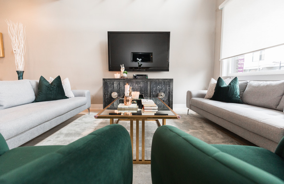 Modelo de salón para visitas abierto minimalista de tamaño medio con paredes grises, suelo de madera clara, televisor colgado en la pared y suelo beige