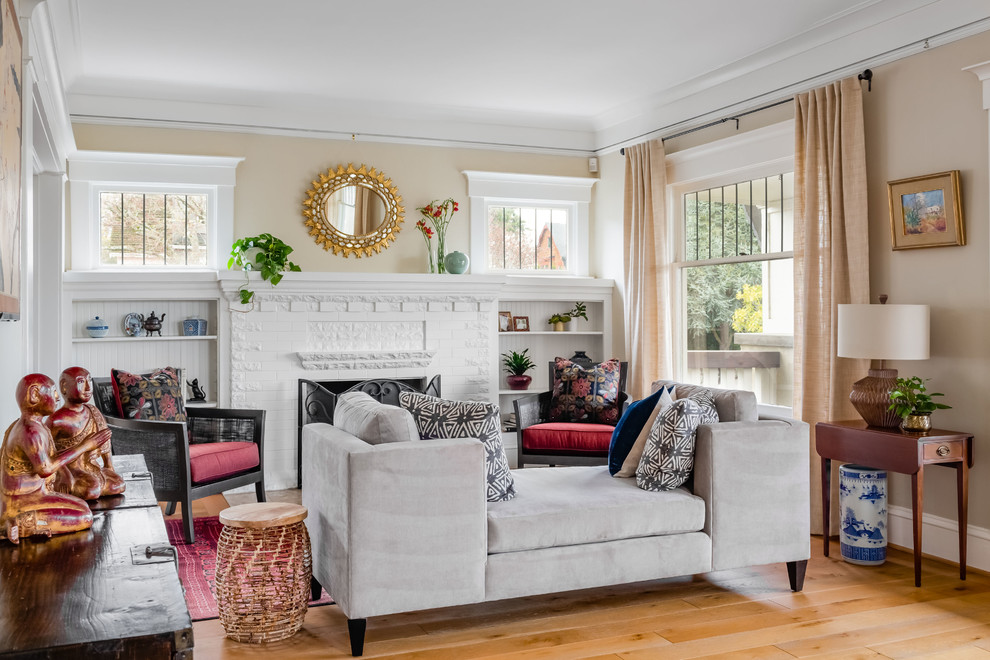 Mittelgroßes, Fernseherloses Stilmix Wohnzimmer mit beiger Wandfarbe, hellem Holzboden, Kamin, Kaminumrandung aus Backstein und beigem Boden in Seattle