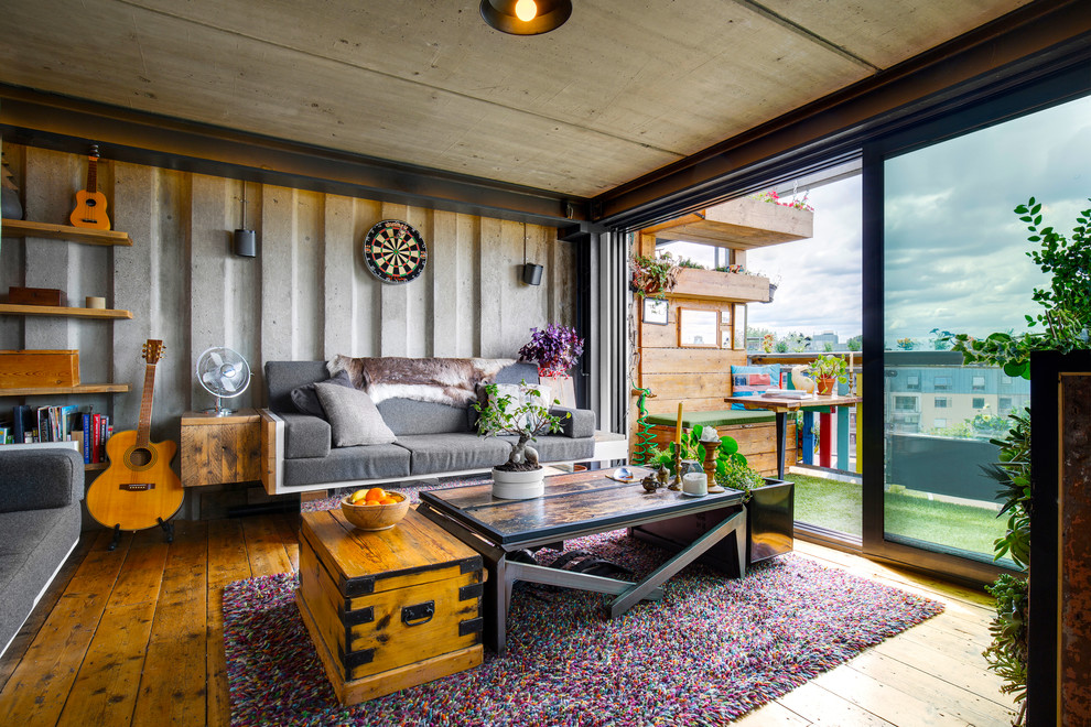 Immagine di un soggiorno boho chic con pareti grigie e pavimento in legno massello medio