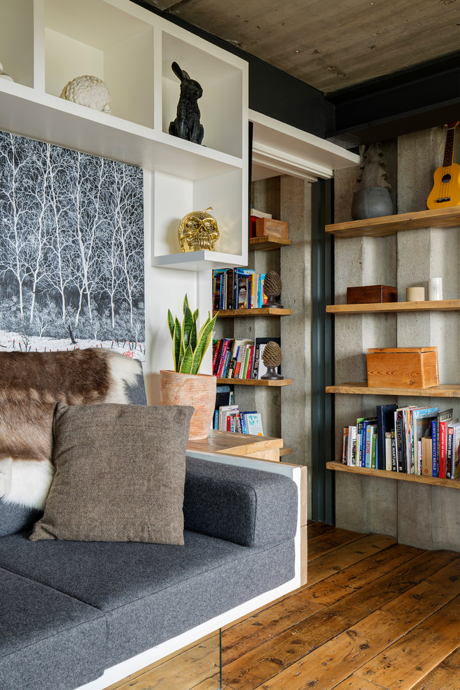 Imagen de salón industrial pequeño con suelo de madera en tonos medios y paredes grises