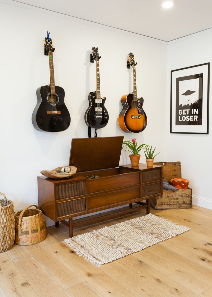 Exempel på ett mellanstort eklektiskt separat vardagsrum, med ett musikrum, vita väggar och ljust trägolv