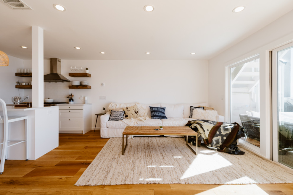Immagine di un soggiorno stile marino stile loft con pareti bianche e pavimento in legno massello medio