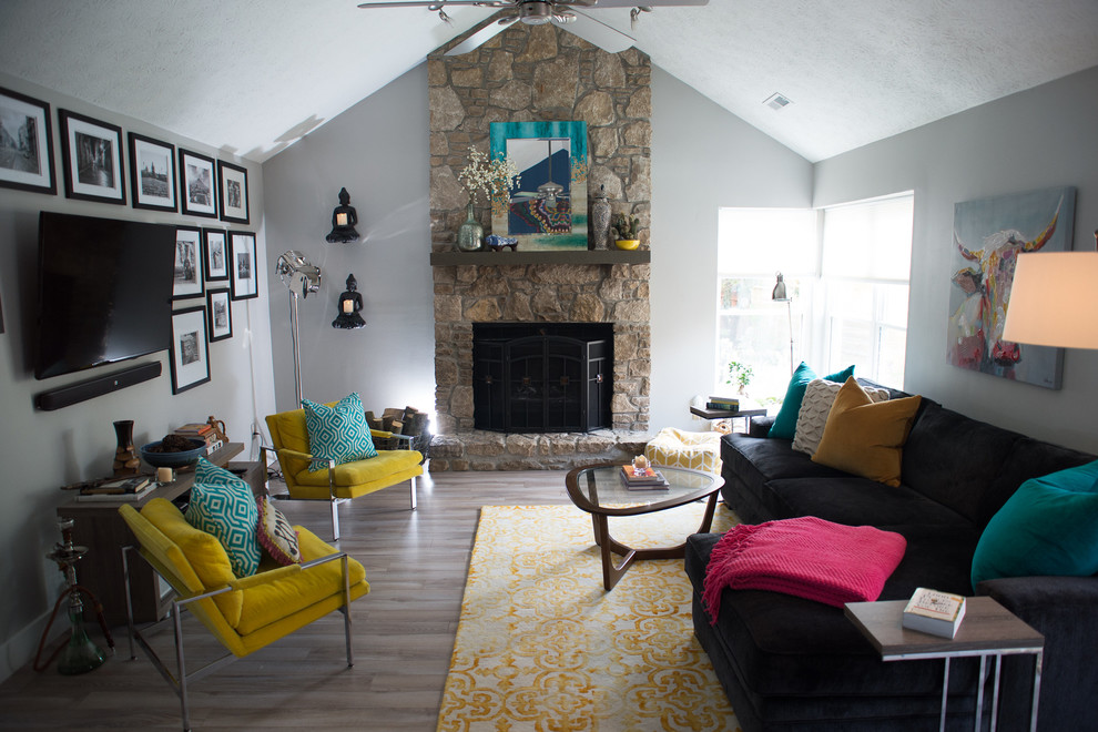 Offenes Eklektisches Wohnzimmer mit grauer Wandfarbe, hellem Holzboden, Kaminumrandung aus Stein und TV-Wand in Indianapolis