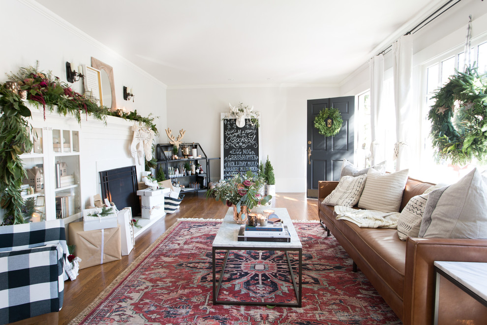 Immagine di un soggiorno classico con pareti bianche, pavimento in legno massello medio, camino classico e pavimento marrone