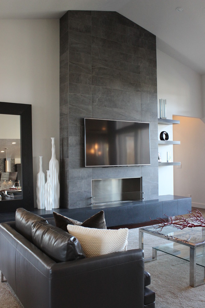 Ejemplo de salón actual con marco de chimenea de baldosas y/o azulejos y televisor colgado en la pared