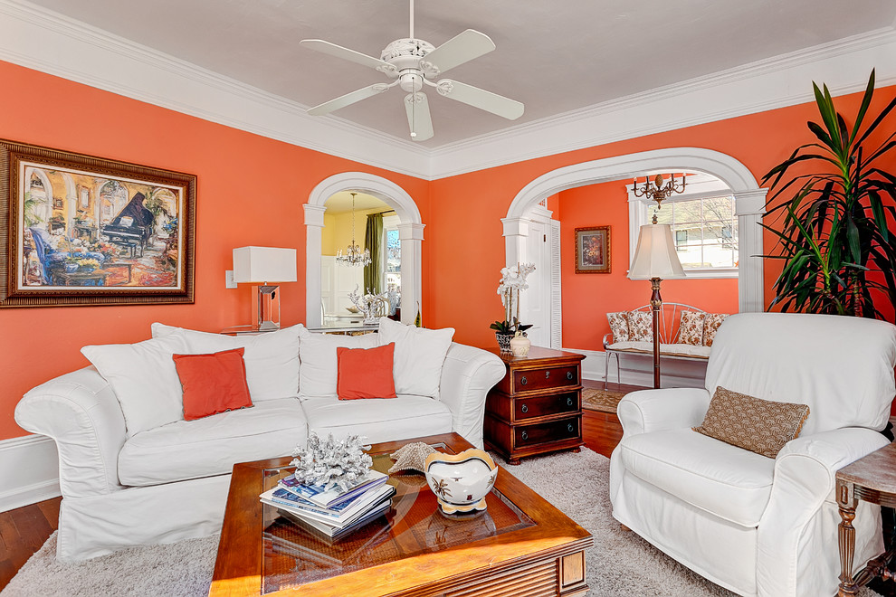 Idéer för små vintage separata vardagsrum, med orange väggar och mellanmörkt trägolv