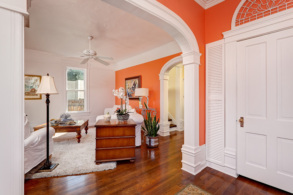 Foto de salón cerrado clásico pequeño con parades naranjas y suelo de madera en tonos medios