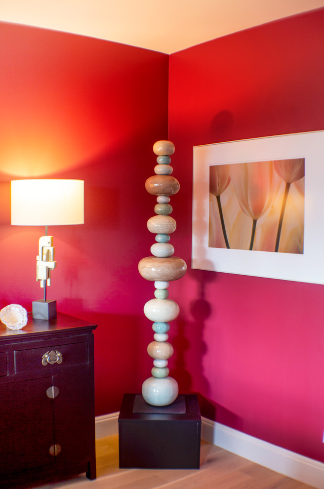 Modelo de salón abierto actual de tamaño medio sin chimenea con paredes rojas, suelo de madera en tonos medios, televisor independiente y suelo marrón