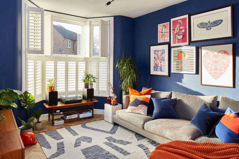 Klassisches Wohnzimmer mit blauer Wandfarbe, braunem Holzboden und braunem Boden in Sonstige