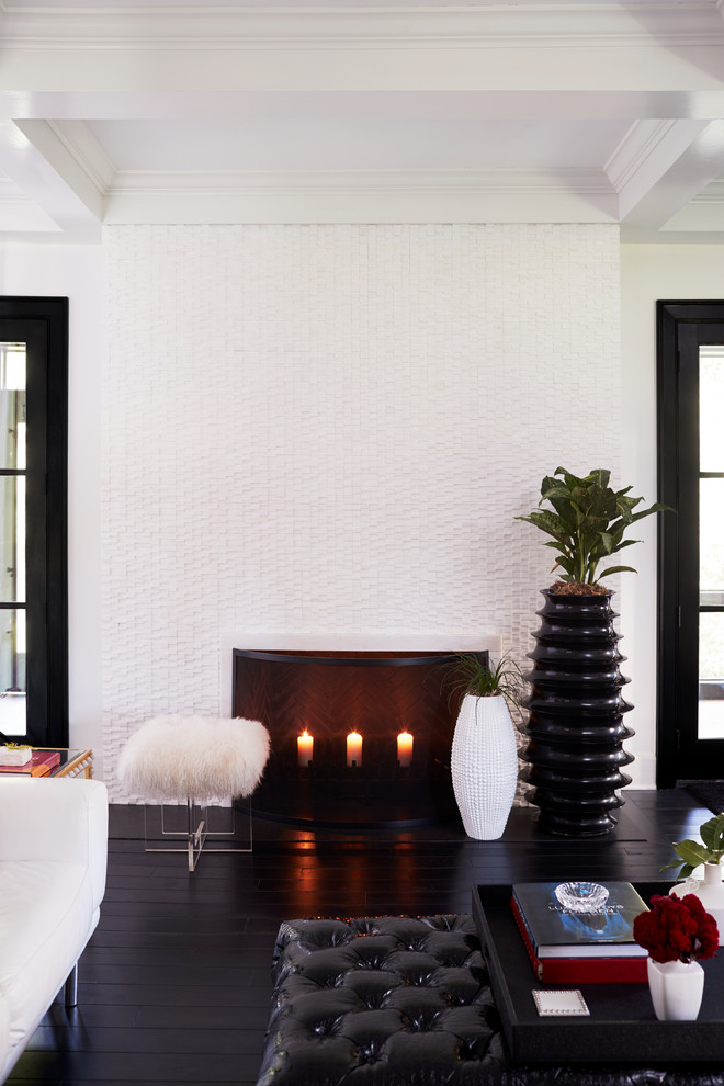 Источник вдохновения для домашнего уюта: гостиная комната в стиле неоклассика (современная классика) с белыми стенами, темным паркетным полом, стандартным камином, фасадом камина из камня и черным полом