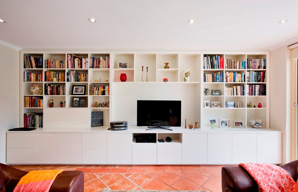 Ejemplo de salón abierto minimalista grande sin chimenea con paredes blancas, suelo de baldosas de terracota y televisor independiente