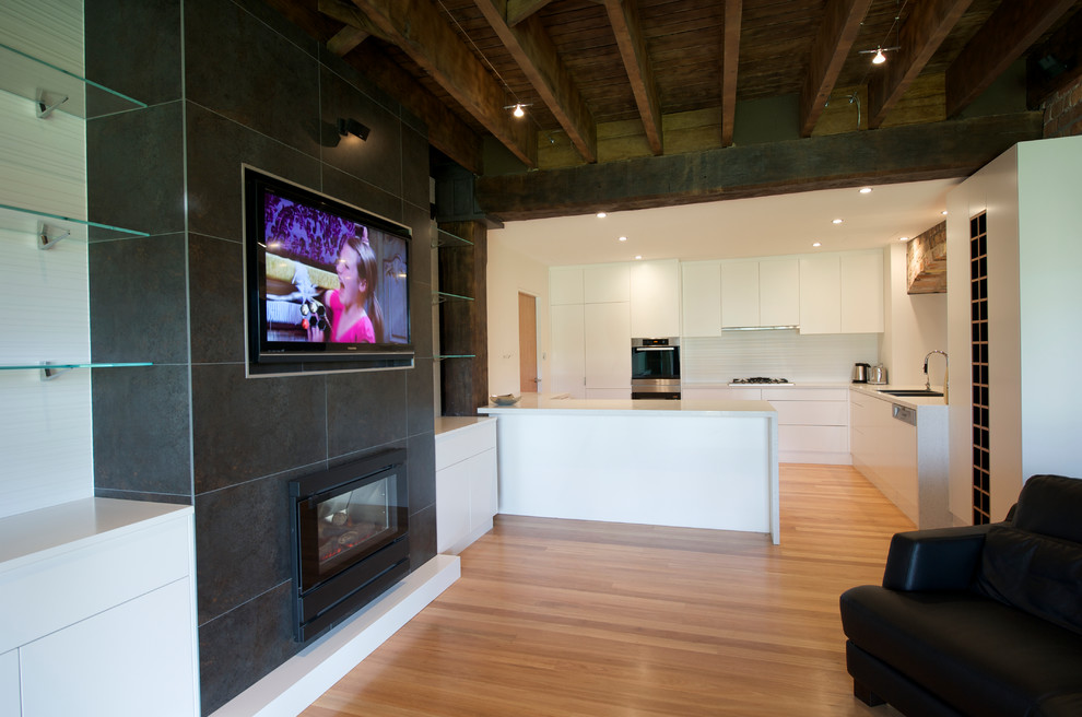 Großes, Offenes Industrial Wohnzimmer mit Kamin, gefliester Kaminumrandung und Multimediawand in Sydney