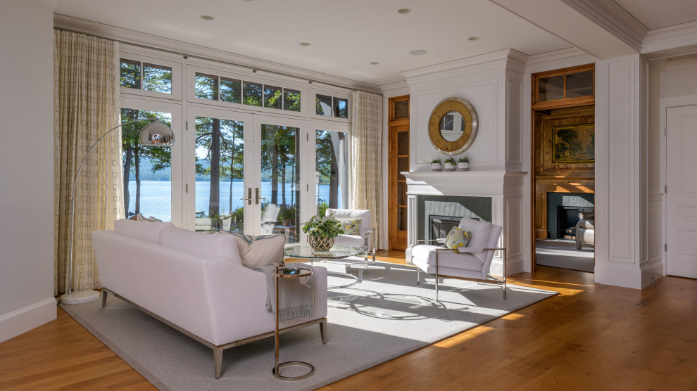 Example of a transitional medium tone wood floor and brown floor living room design in Boston with white walls and a standard fireplace