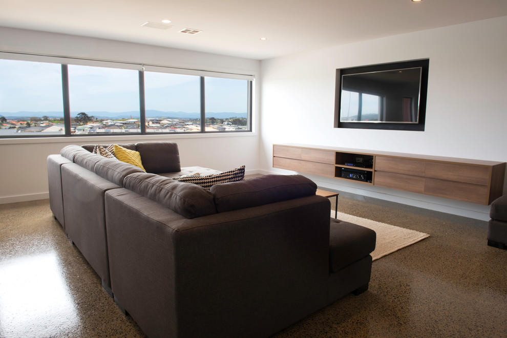Idée de décoration pour un grand salon minimaliste ouvert avec un mur blanc, sol en béton ciré et un téléviseur encastré.