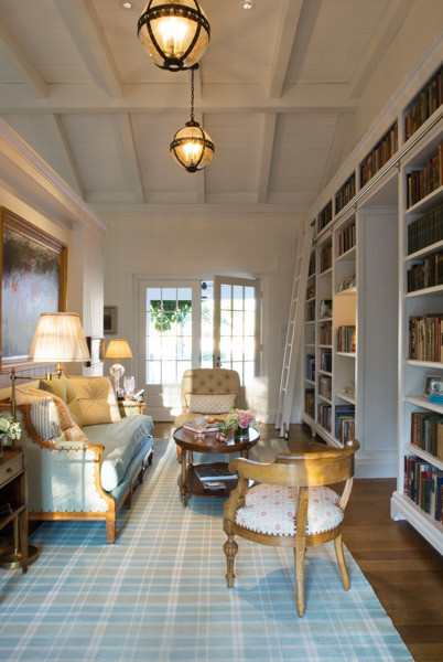 Foto di un piccolo soggiorno chic aperto con libreria, pareti bianche, pavimento in legno massello medio, nessun camino e nessuna TV