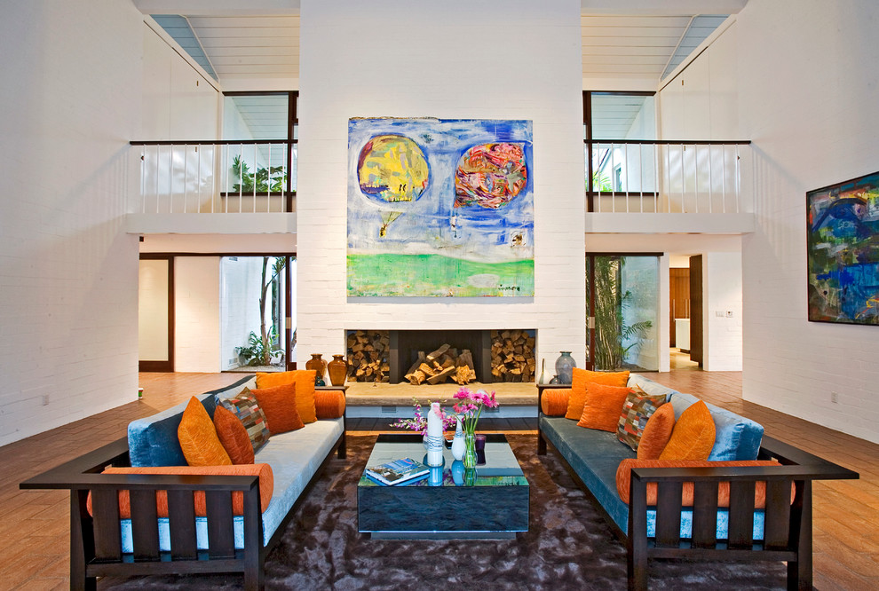 Идея дизайна: гостиная комната в стиле ретро с белыми стенами, паркетным полом среднего тона и синим диваном