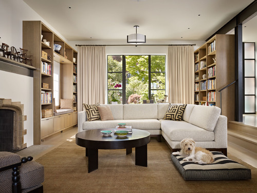 cream colored couch with brown round table and dog. 