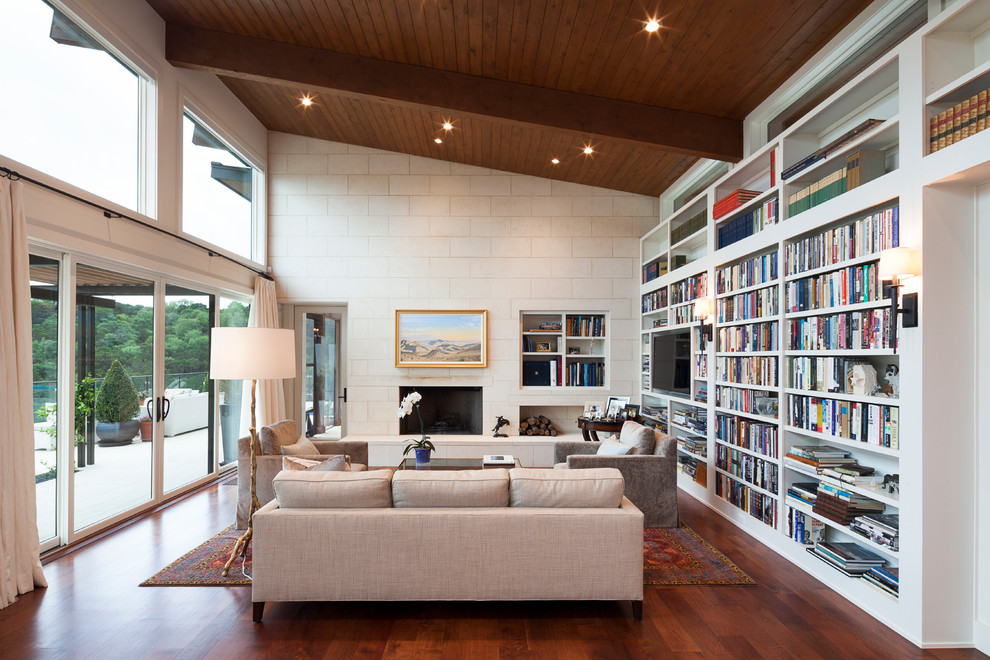 Cette image montre un salon design avec une bibliothèque ou un coin lecture, une cheminée standard et un téléviseur encastré.