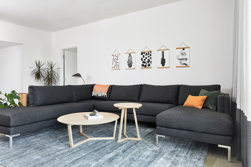 Ispirazione per un soggiorno moderno di medie dimensioni e aperto con pareti bianche, parquet chiaro e pavimento grigio