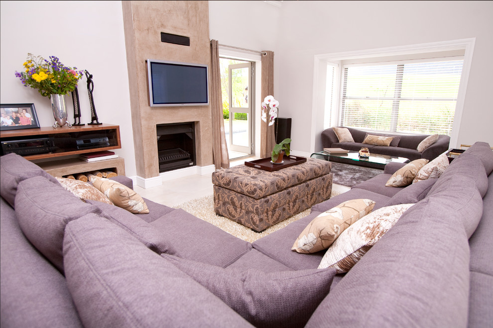 Photo of a contemporary grey and purple living room in Other with a concrete fireplace surround and white walls.