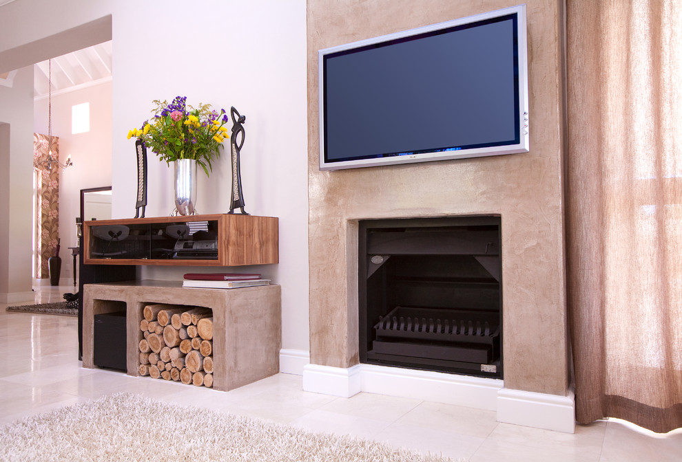 Contemporary living room in Other with a concrete fireplace surround and white walls.