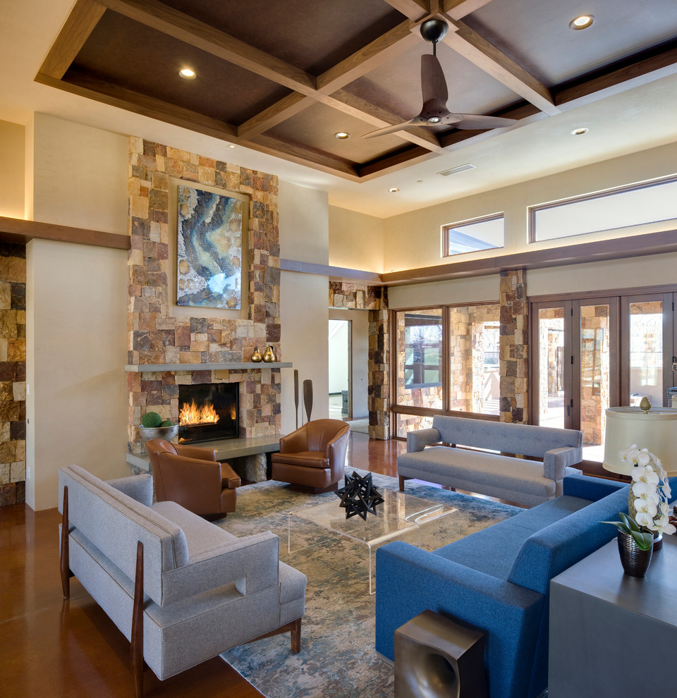 Large contemporary open plan living room in Albuquerque with beige walls, concrete flooring, a standard fireplace, a stone fireplace surround and no tv.