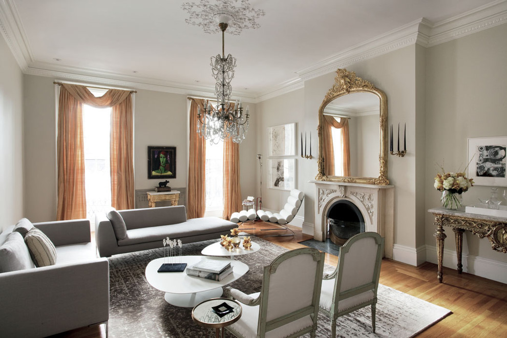 Großes, Fernseherloses Stilmix Wohnzimmer mit beiger Wandfarbe, braunem Holzboden, Kamin und Kaminumrandung aus Stein in Boston