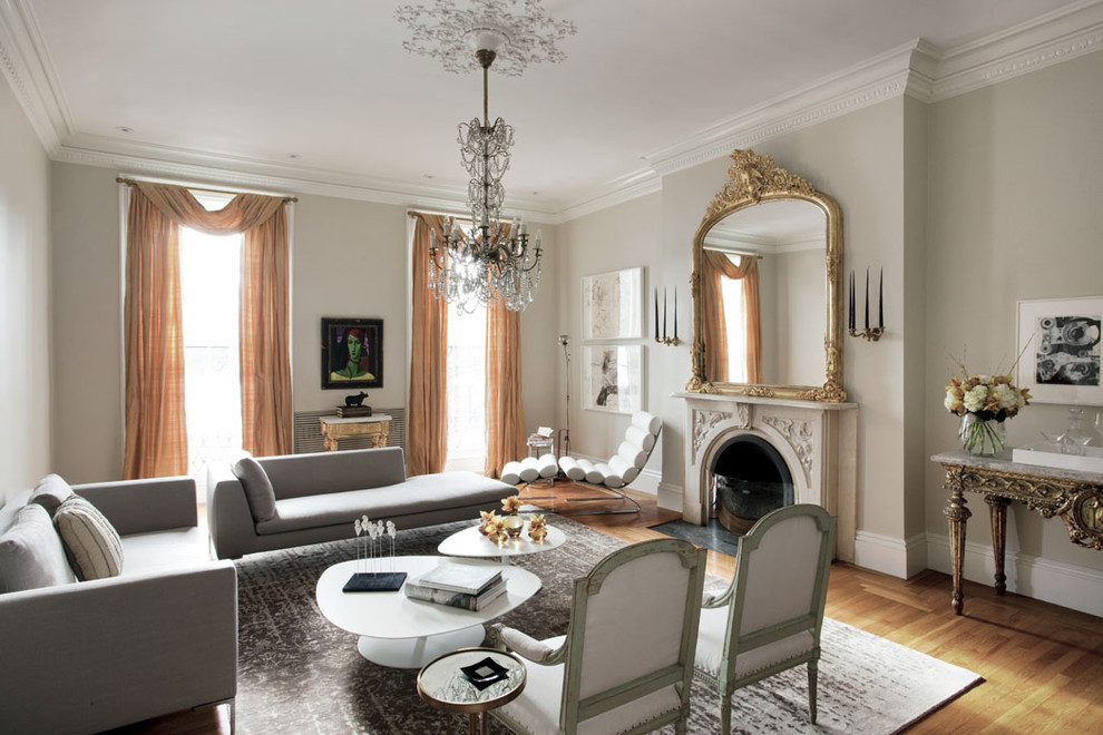 Example of a large eclectic medium tone wood floor living room design in Boston with beige walls, a standard fireplace, no tv and a stone fireplace