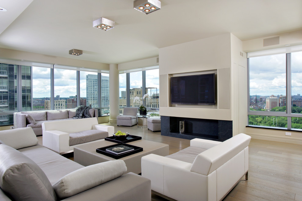 Großes Modernes Wohnzimmer mit TV-Wand, weißer Wandfarbe und hellem Holzboden in Boston