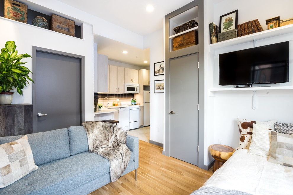 Идея дизайна: маленькая открытая гостиная комната в современном стиле с белыми стенами, паркетным полом среднего тона и отдельно стоящим телевизором для на участке и в саду