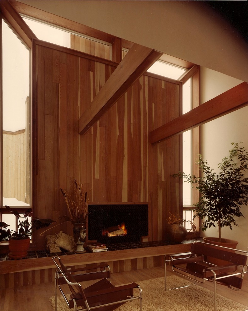 Immagine di un grande soggiorno minimalista stile loft con pareti beige, parquet chiaro, camino classico e cornice del camino in legno