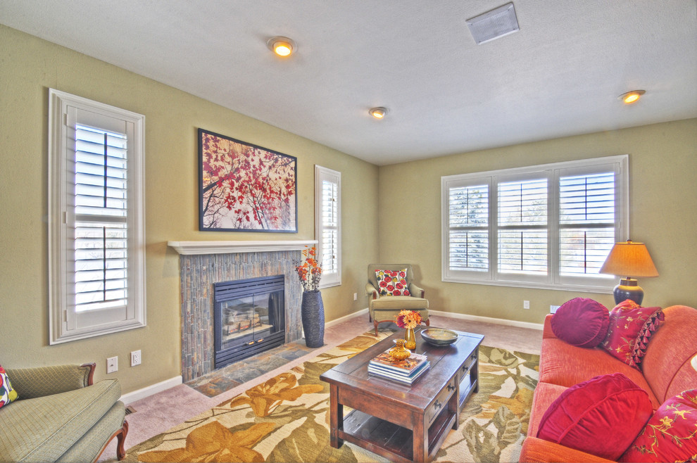 Classic enclosed living room in Denver with beige walls, carpet, a standard fireplace and a stone fireplace surround.