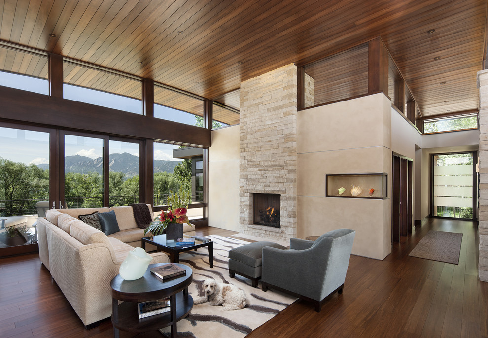 Offenes Modernes Wohnzimmer mit Bambusparkett, Kamin, Kaminumrandung aus Stein und beiger Wandfarbe in Denver