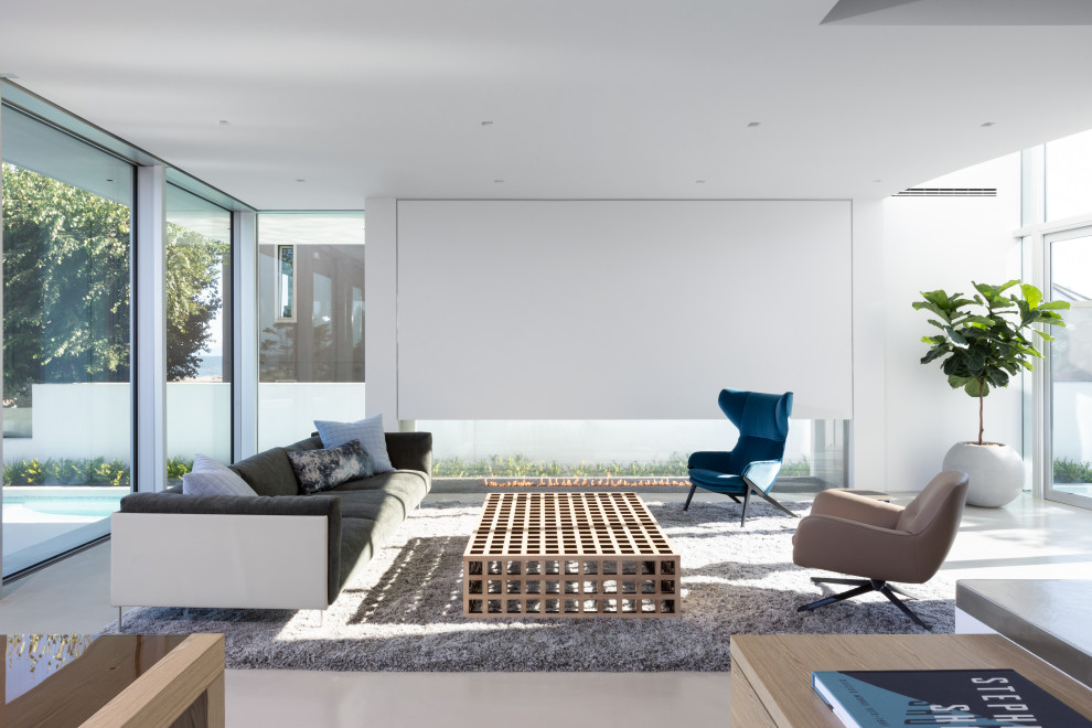 Idée de décoration pour un grand salon design ouvert avec une salle de réception, un mur blanc, sol en béton ciré, une cheminée double-face et un sol gris.