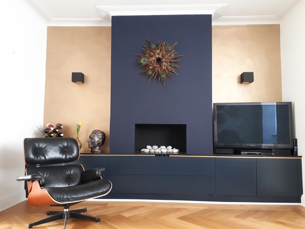 Photo of a medium sized eclectic formal open plan living room in London with multi-coloured walls, light hardwood flooring, a ribbon fireplace, a plastered fireplace surround, a freestanding tv and brown floors.