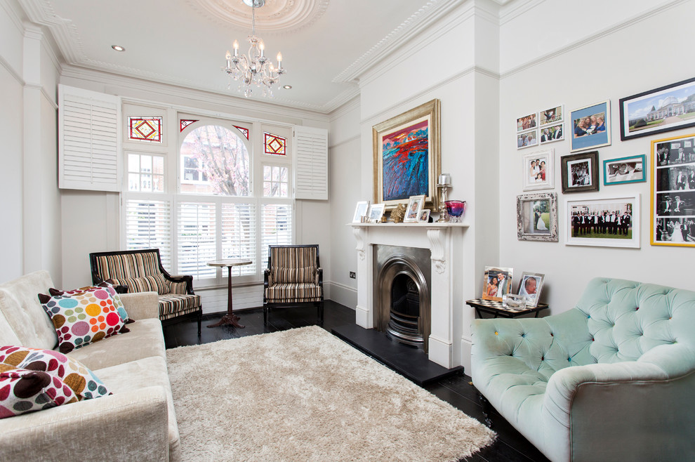 Contemporary living room in London with white walls, a standard fireplace and black floors.