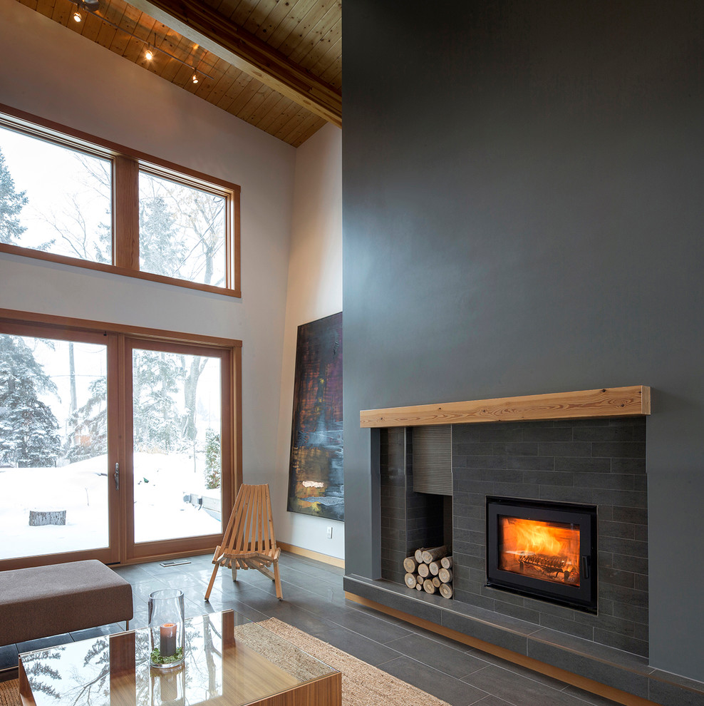 This is an example of a contemporary open plan living room in Edmonton with a wood burning stove, a brick fireplace surround, no tv and porcelain flooring.