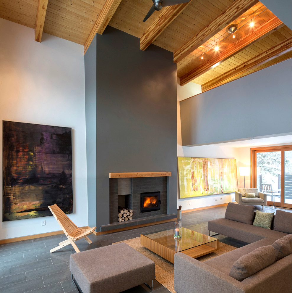 Foto di un soggiorno contemporaneo aperto con stufa a legna, cornice del camino in mattoni, nessuna TV e pavimento in gres porcellanato