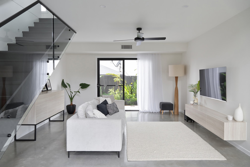 Modelo de salón actual de tamaño medio con paredes blancas, suelo de cemento y suelo gris