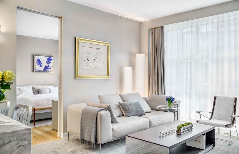 Mittelgroßes, Repräsentatives Modernes Wohnzimmer mit beiger Wandfarbe, Teppichboden, TV-Wand und grauem Boden in New York