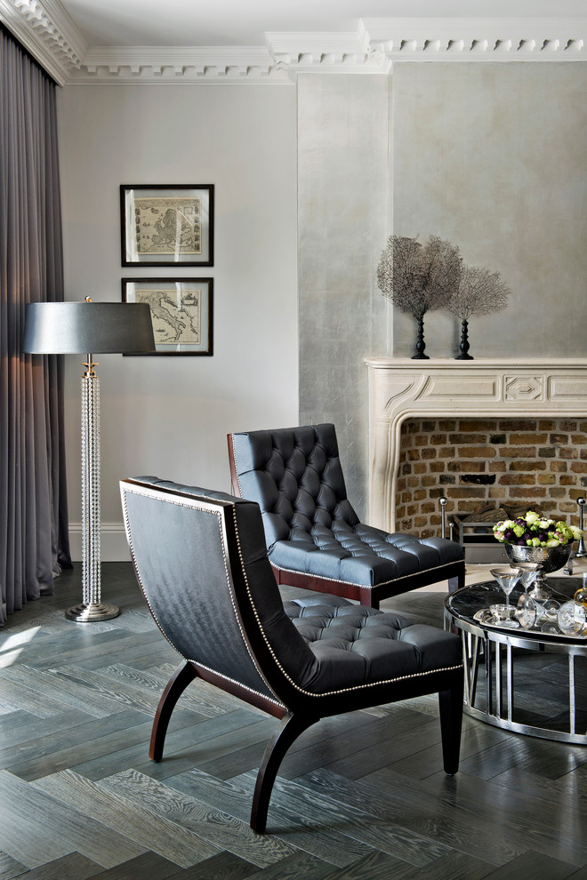 На фото: гостиная комната в стиле неоклассика (современная классика) с серыми стенами, темным паркетным полом и стандартным камином